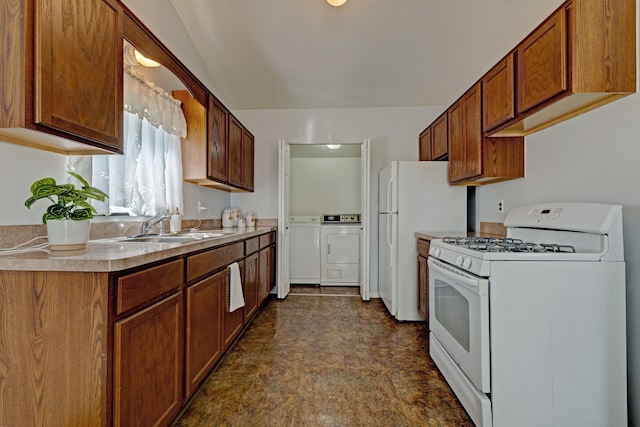 kitchen featuring light countertops, white appliances, brown cabinets, a sink, and washing machine and dryer