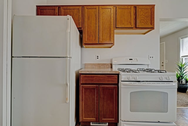 kitchen with light countertops, brown cabinetry, and white appliances