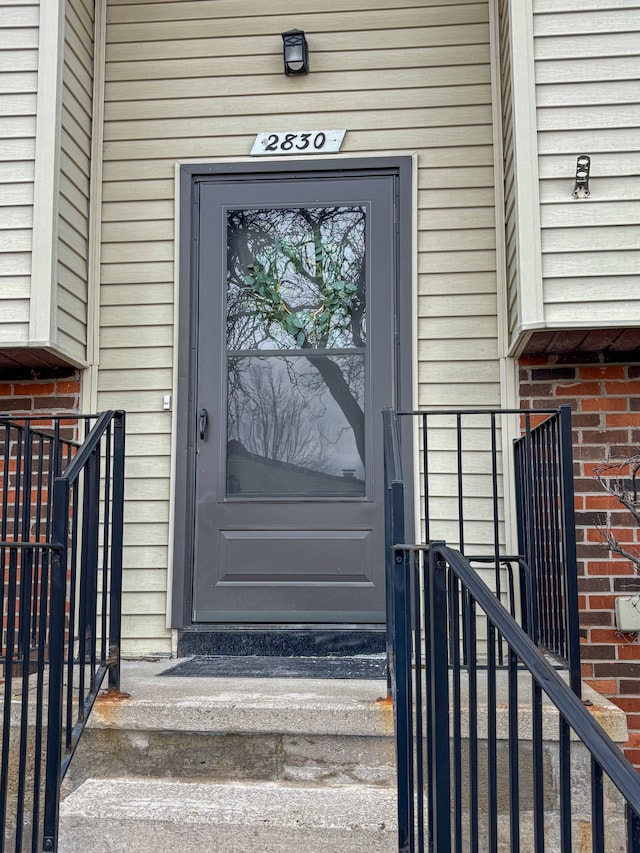 view of exterior entry featuring brick siding