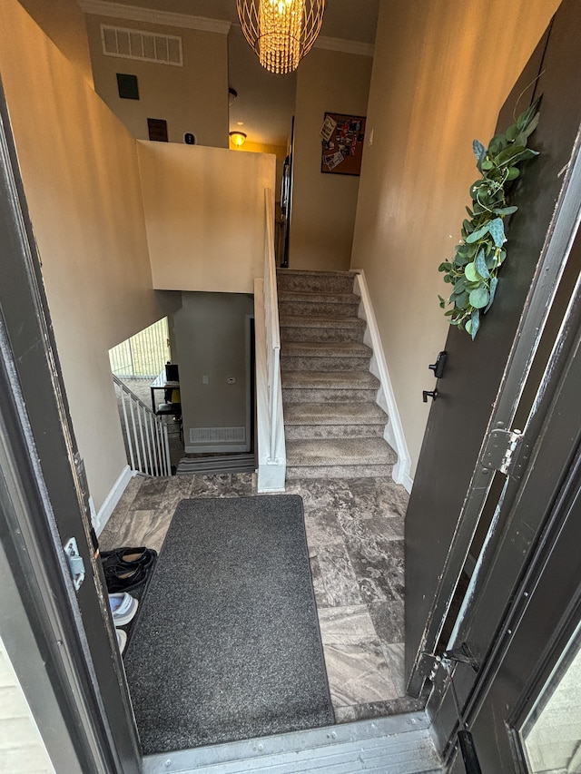 stairway featuring crown molding, baseboards, and visible vents