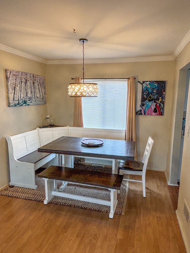 dining space featuring breakfast area, wood finished floors, baseboards, and ornamental molding