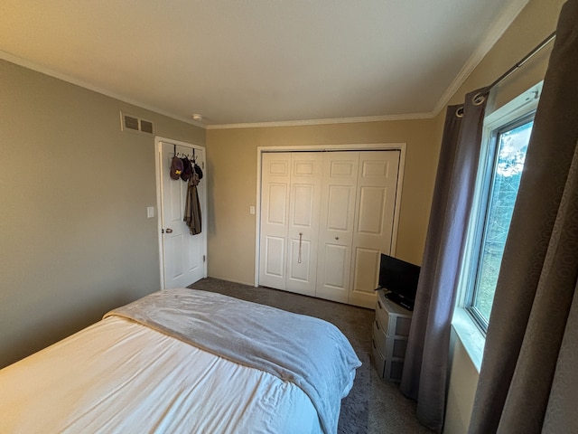 bedroom with a closet, multiple windows, visible vents, and dark colored carpet