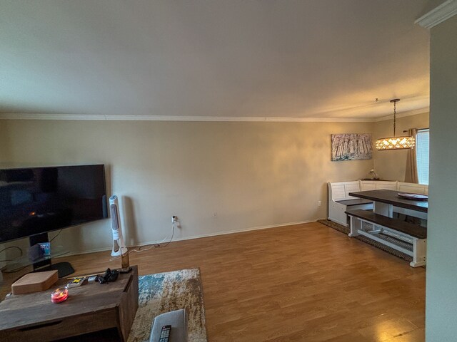 living room featuring crown molding, baseboards, and wood finished floors