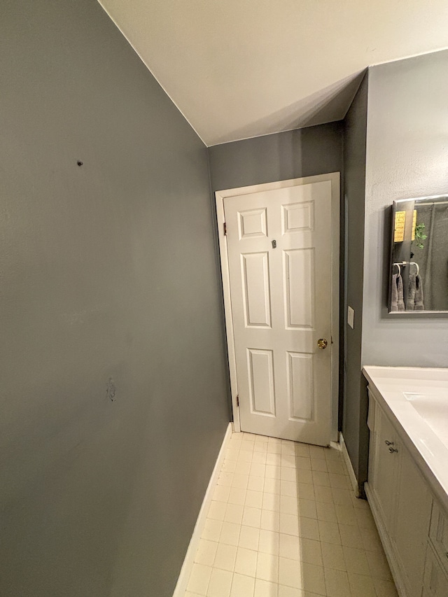 bathroom with tile patterned floors, baseboards, and vanity