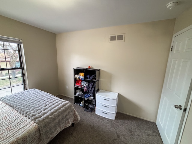 bedroom with baseboards, visible vents, and dark carpet