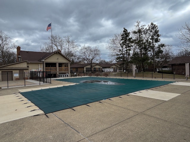 community pool with fence and a patio area