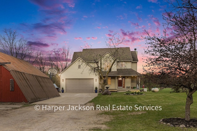 traditional home featuring a lawn, covered porch, concrete driveway, and an attached garage