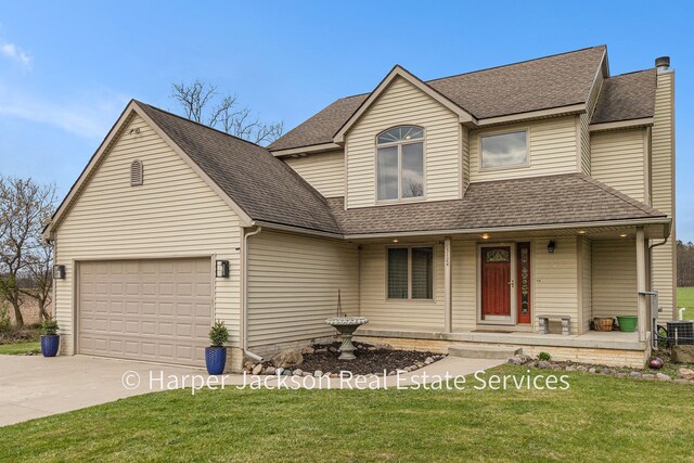 traditional-style house with covered porch, a shingled roof, a front lawn, concrete driveway, and an attached garage