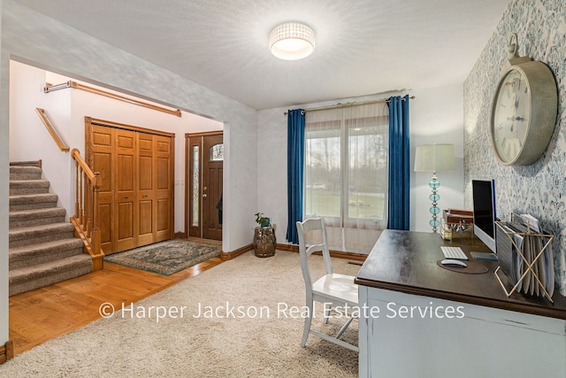 carpeted home office with wood finished floors and baseboards