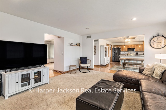 living room with visible vents, ceiling fan, baseboards, recessed lighting, and light wood finished floors