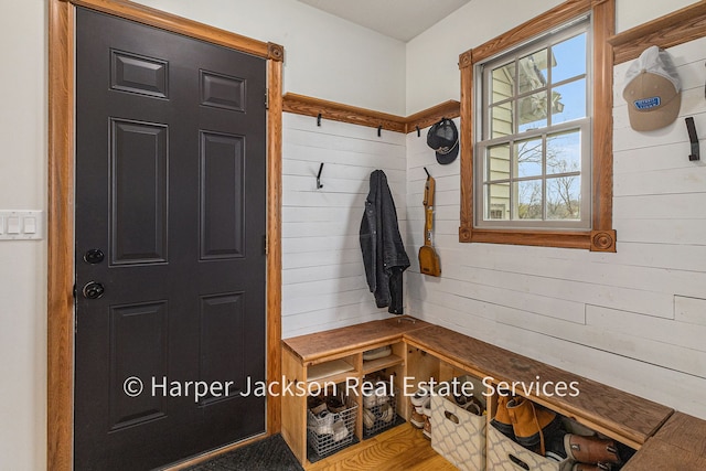 mudroom featuring wooden walls