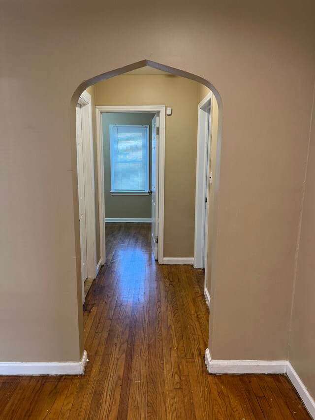 10026 Coyle St, Detroit, MI 48227 - corridor featuring baseboards, wood finished floors, and arched walkways