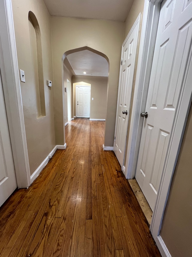 10026 Coyle St, Detroit, MI 48227 - corridor featuring arched walkways, baseboards, and hardwood / wood-style flooring