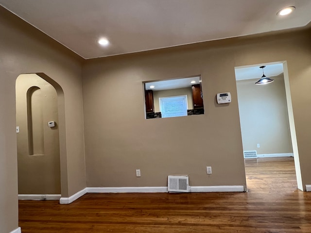 10026 Coyle St, Detroit, MI 48227 - empty room with wood finished floors, arched walkways, baseboards, and visible vents