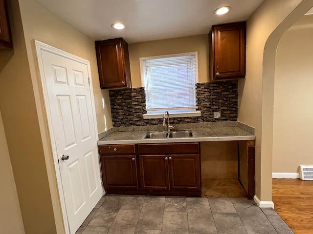 10026 Coyle St, Detroit, MI 48227 - kitchen featuring baseboards, recessed lighting, arched walkways, a sink, and backsplash