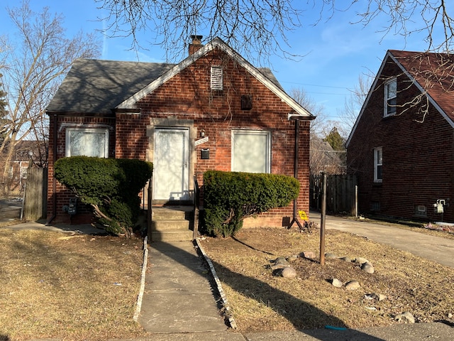 10026 Coyle St, Detroit, MI 48227 - view of front facade with a chimney, brick siding, and roof with shingles