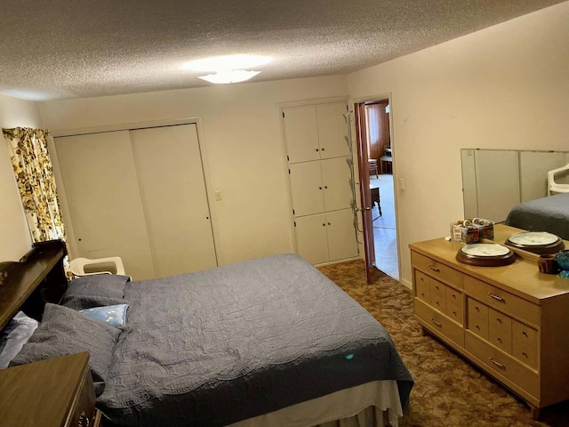 bedroom with dark carpet and a textured ceiling