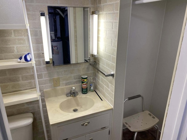 half bathroom featuring vanity, backsplash, and toilet