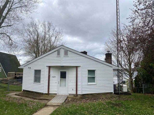 view of front of house with a chimney and fence