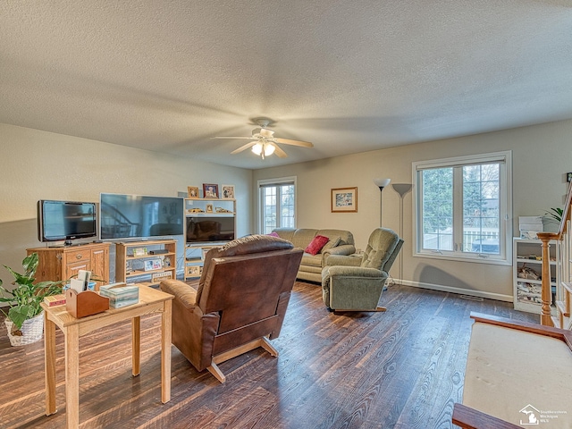 living room featuring dark wood-style floors, ceiling fan, baseboards, and a textured ceiling