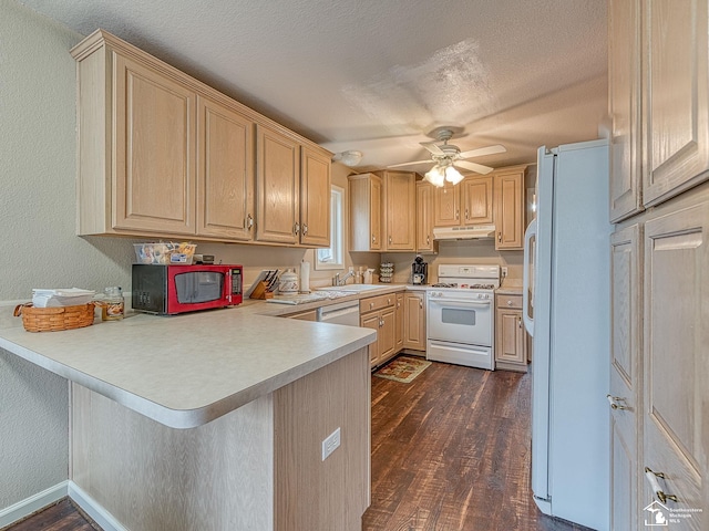 kitchen with a peninsula, under cabinet range hood, light brown cabinets, white appliances, and dark wood-type flooring