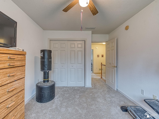 bedroom with carpet flooring, baseboards, a textured ceiling, visible vents, and a closet
