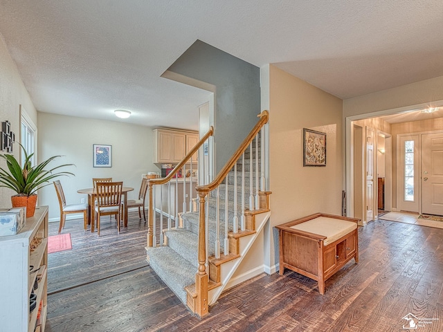 entryway featuring baseboards, dark wood-style floors, stairway, and a textured ceiling