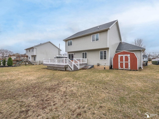 rear view of house featuring a yard, an outbuilding, a deck, and a storage shed