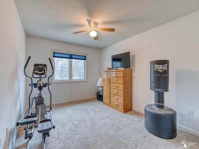 workout room featuring a textured ceiling, baseboards, carpet, and a ceiling fan