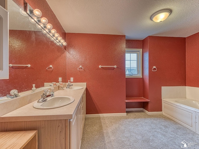 bathroom with double vanity, a sink, a garden tub, and a textured ceiling