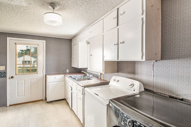 12225 Miller Rd, Grand Blanc, MI 48449 - laundry area featuring cabinet space, a textured ceiling, a sink, and washer and dryer