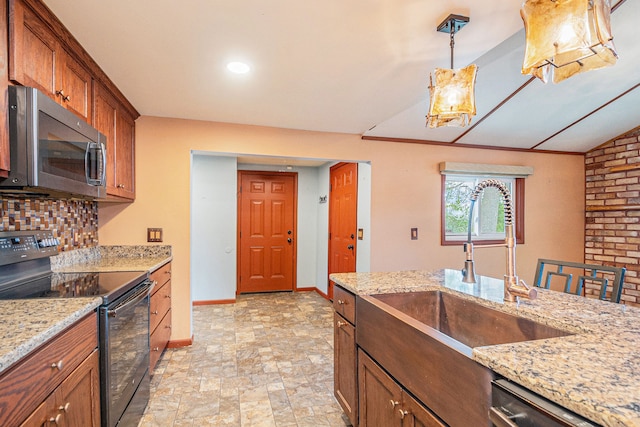 kitchen featuring tasteful backsplash, stone finish flooring, a sink, stainless steel appliances, and baseboards