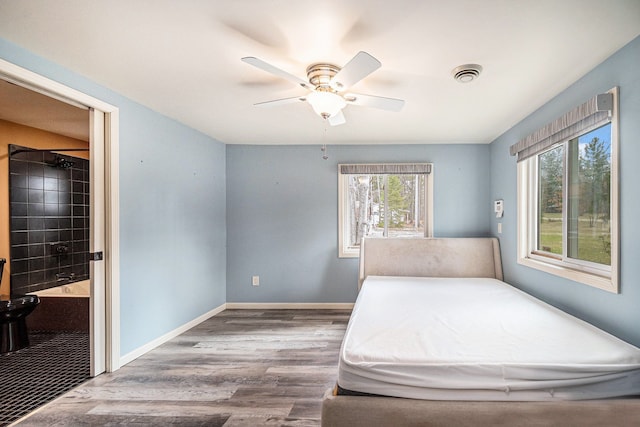 bedroom featuring visible vents, baseboards, a ceiling fan, and wood finished floors