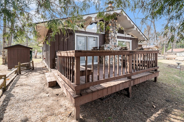 wooden deck featuring an outbuilding and a storage unit