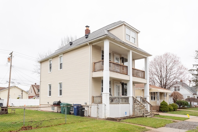 880 White Ave, Lincoln Park, MI 48146 - view of home's exterior featuring a balcony, a chimney, a porch, fence, and a lawn