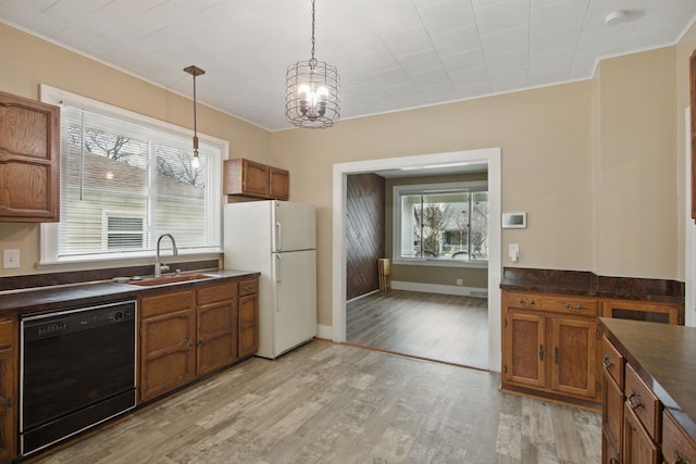 880 White Ave, Lincoln Park, MI 48146 - kitchen featuring freestanding refrigerator, brown cabinetry, black dishwasher, a sink, and dark countertops