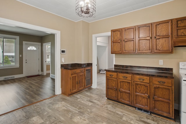 880 White Ave, Lincoln Park, MI 48146 - kitchen with light wood-type flooring, brown cabinets, an inviting chandelier, and dark countertops