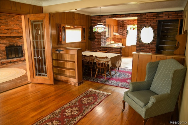 1521 Ferris Ave, Lincoln Park, MI 48146 - living room with a fireplace, hardwood / wood-style flooring, wood walls, and brick wall