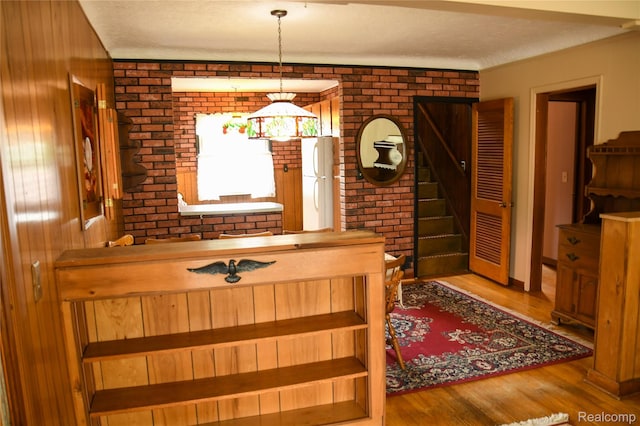 1521 Ferris Ave, Lincoln Park, MI 48146 - dining space featuring brick wall, wood finished floors, and stairway