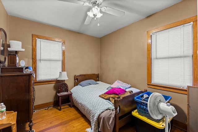 bedroom with baseboards, wood finished floors, and ceiling fan