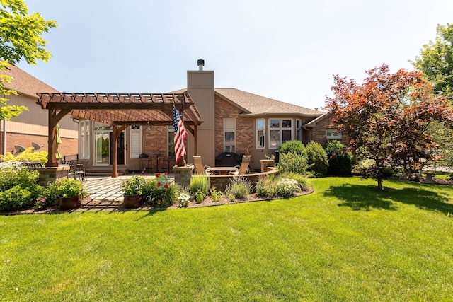 back of house with a pergola, a yard, brick siding, and a patio area