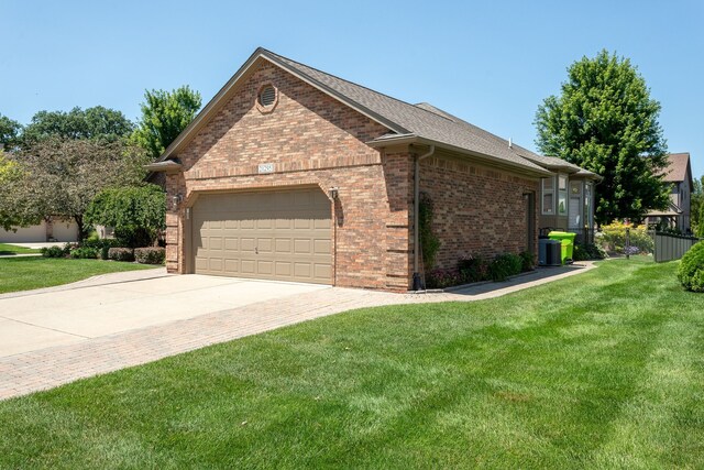 view of home's exterior featuring driveway, a yard, brick siding, and a garage
