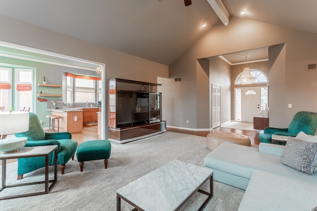 living room with beam ceiling, high vaulted ceiling, visible vents, baseboards, and ceiling fan with notable chandelier