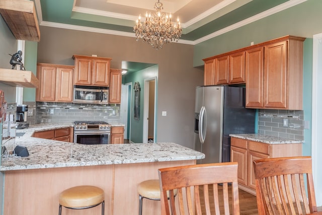 kitchen with light stone counters, stainless steel appliances, crown molding, and backsplash
