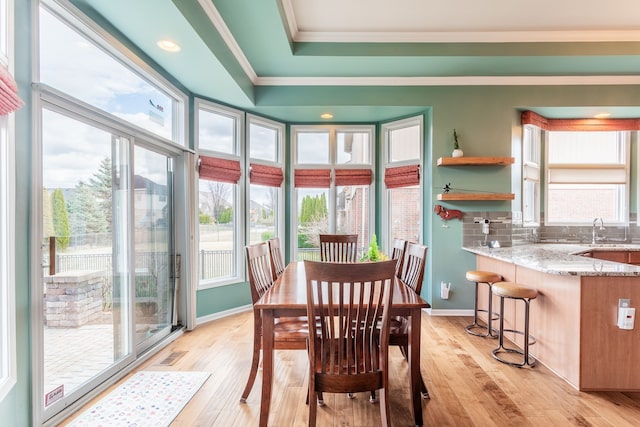 dining space with ornamental molding, visible vents, a wealth of natural light, and light wood-type flooring