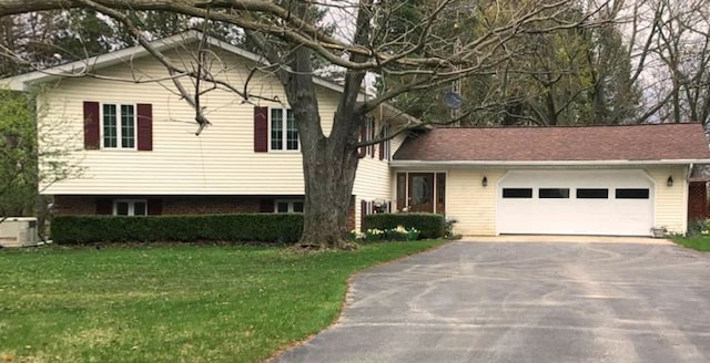 split level home featuring central AC, aphalt driveway, a front yard, and a garage