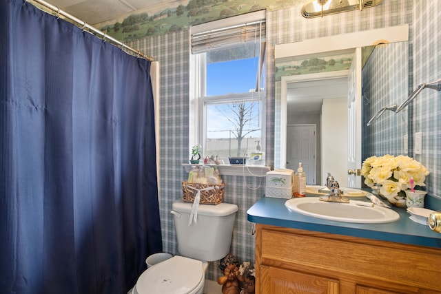 bathroom featuring wallpapered walls, toilet, and vanity