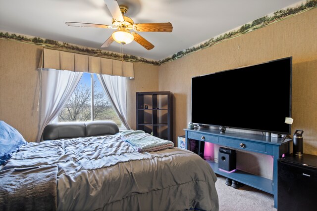 carpeted bedroom featuring wallpapered walls and a ceiling fan