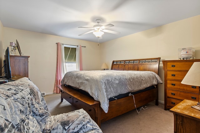 bedroom with a ceiling fan, baseboards, and light colored carpet