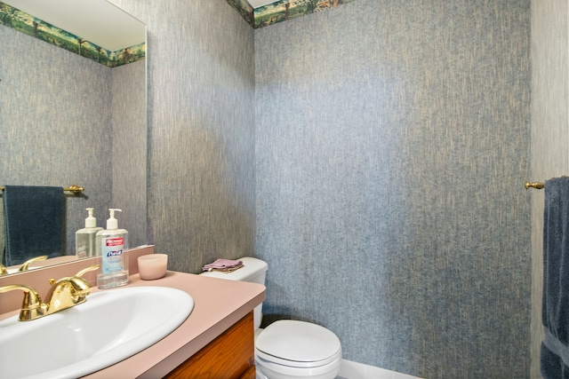 half bath featuring toilet and vanity
